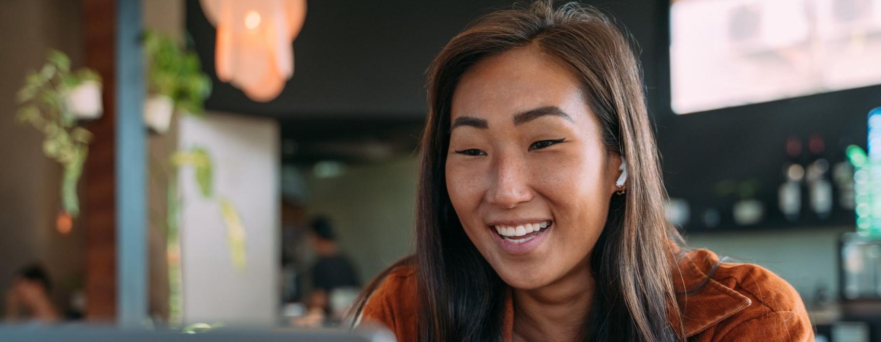 a woman smiling while working on laptop